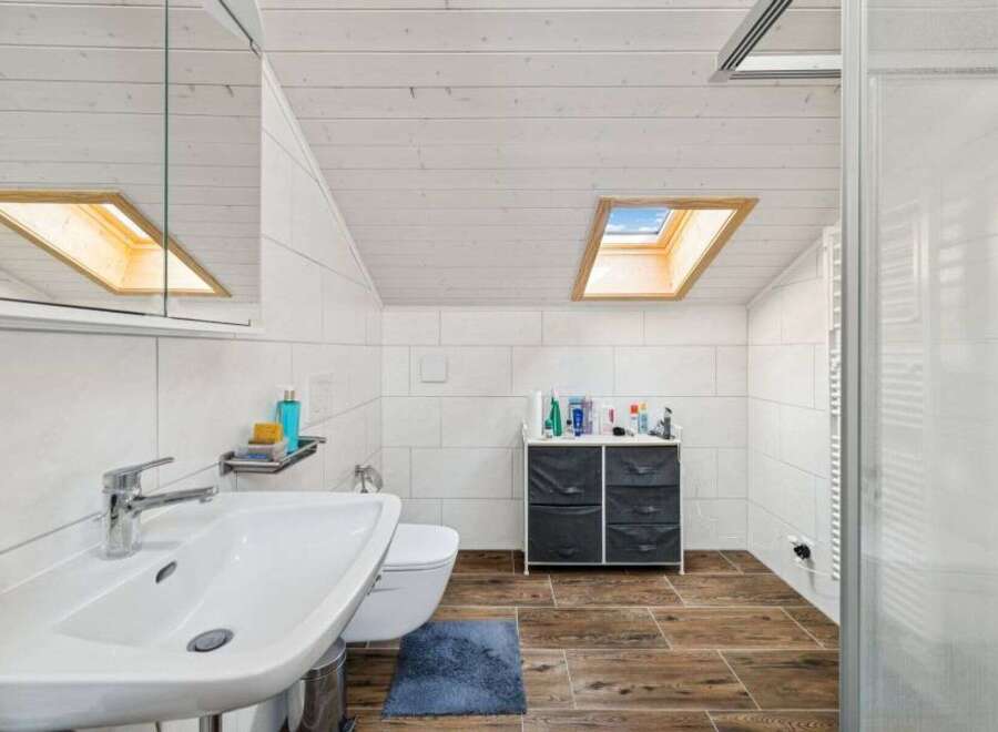 This modern bathroom features a sleek design with a skylight that floods the space with natural light.