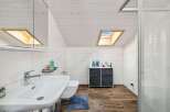 This modern bathroom features a sleek design with a skylight that floods the space with natural light.