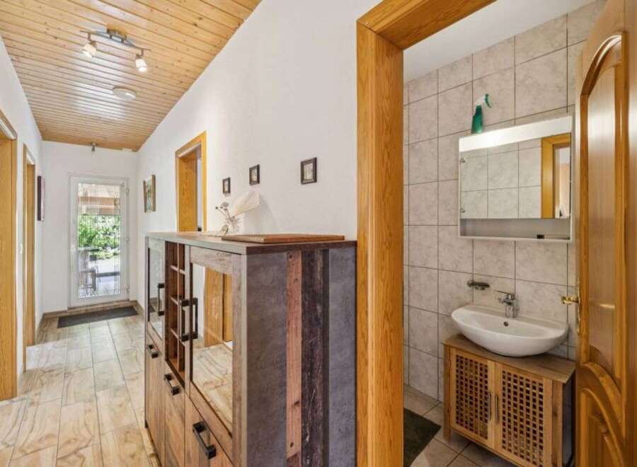 Step into this inviting hallway, featuring a stylish wooden ceiling and elegant flooring.