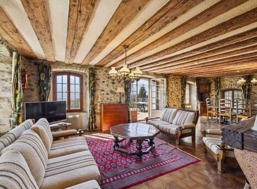 Step into rustic elegance with this stunning living space, featuring exposed wooden beams and stone walls that exude warmth and character.