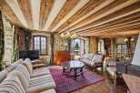 Step into rustic elegance with this stunning living space, featuring exposed wooden beams and stone walls that exude warmth and character.