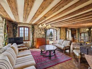 Step into rustic elegance with this stunning living space, featuring exposed wooden beams and stone walls that exude warmth and character.