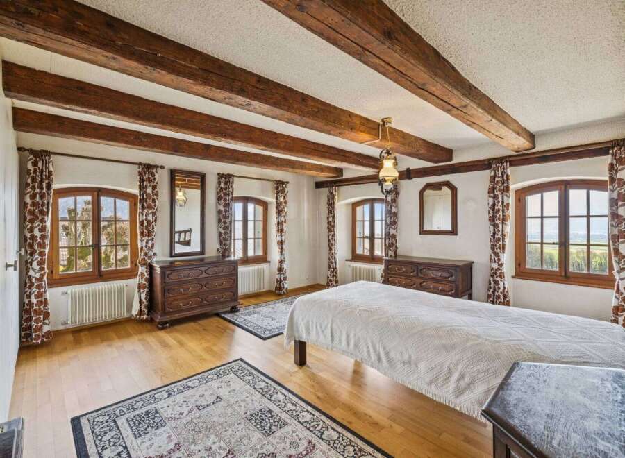 Step into a charming bedroom with rustic wooden beams and elegant design.