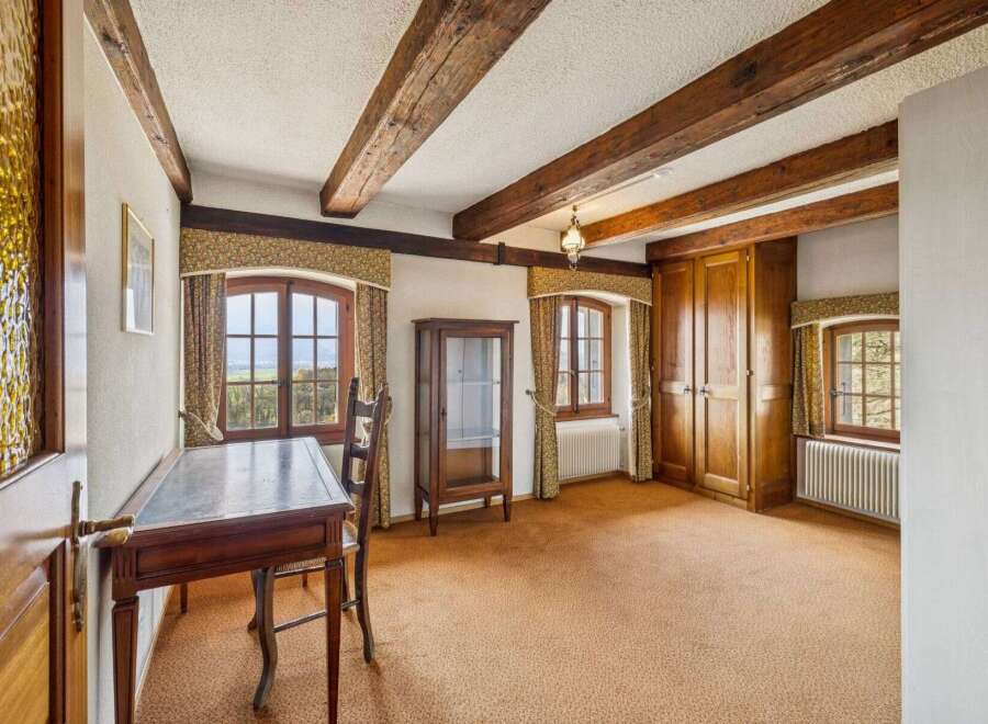 Step into this charming room, featuring exposed wooden beams that add a touch of rustic elegance.