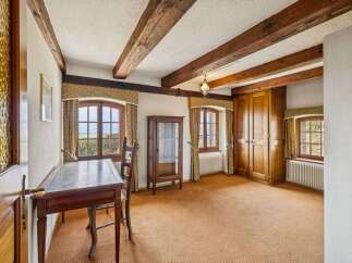 Step into this charming room, featuring exposed wooden beams that add a touch of rustic elegance.