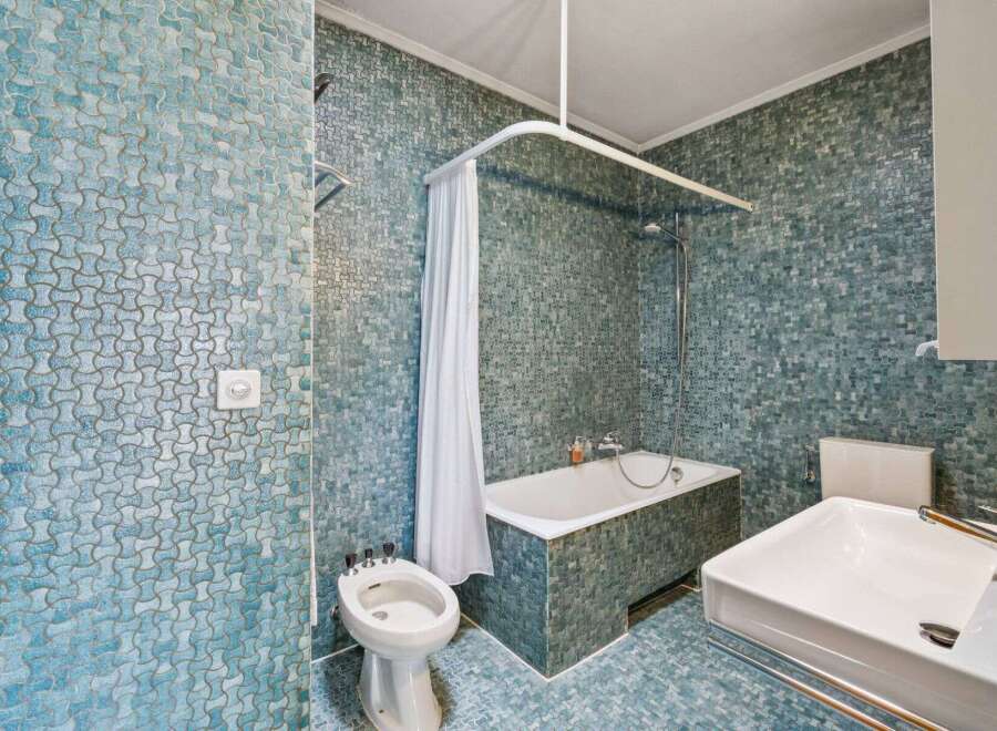 Step into this unique bathroom featuring stunning blue mosaic tiles that create a captivating visual appeal.