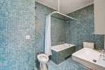 Step into this unique bathroom featuring stunning blue mosaic tiles that create a captivating visual appeal.
