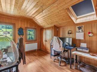 This charming wooden-paneled room offers a cozy and inviting atmosphere, perfect for a home office or creative space.