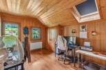 This charming wooden-paneled room offers a cozy and inviting atmosphere, perfect for a home office or creative space.
