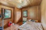 This cozy bedroom features beautiful wooden paneling and a warm, inviting atmosphere.
