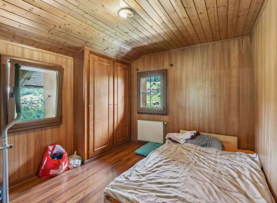 This cozy bedroom features beautiful wooden paneling and a warm, inviting atmosphere.