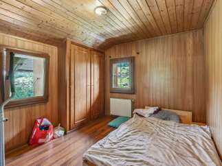 This cozy bedroom features beautiful wooden paneling and a warm, inviting atmosphere.