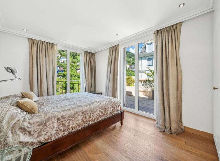 Experience luxury in this stunning bedroom featuring a spacious bed and elegant curtains.