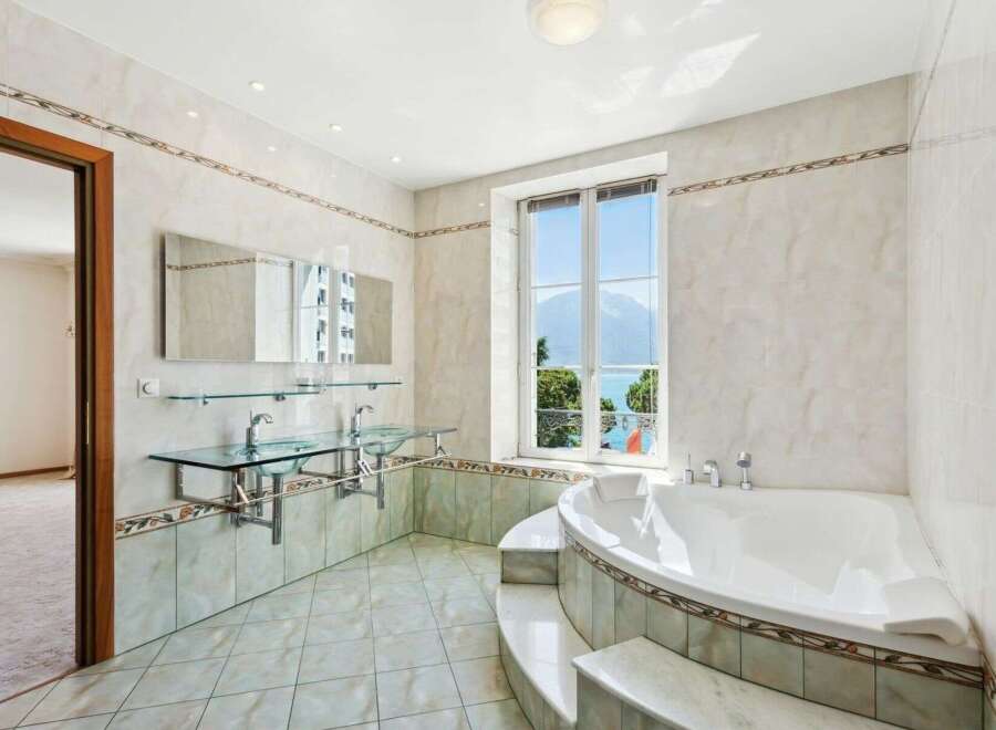 This luxurious bathroom boasts a stunning design with a large window offering breathtaking views.