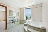 This luxurious bathroom boasts a stunning design with a large window offering breathtaking views.