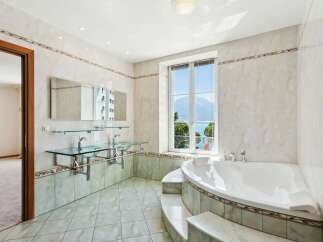 This luxurious bathroom boasts a stunning design with a large window offering breathtaking views.