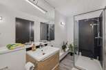 Step into this modern bathroom featuring a sleek glass shower and a stylish vanity.