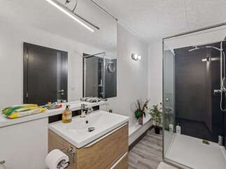 Step into this modern bathroom featuring a sleek glass shower and a stylish vanity.
