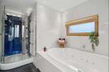 Indulge in luxury within this stunning bathroom, featuring a sleek glass shower and a relaxing jacuzzi tub.