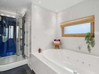 Indulge in luxury within this stunning bathroom, featuring a sleek glass shower and a relaxing jacuzzi tub.