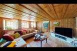 This cozy living room features a warm, inviting atmosphere with its wooden ceiling and walls.