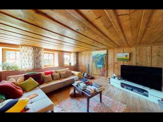 This cozy living room features a warm, inviting atmosphere with its wooden ceiling and walls.