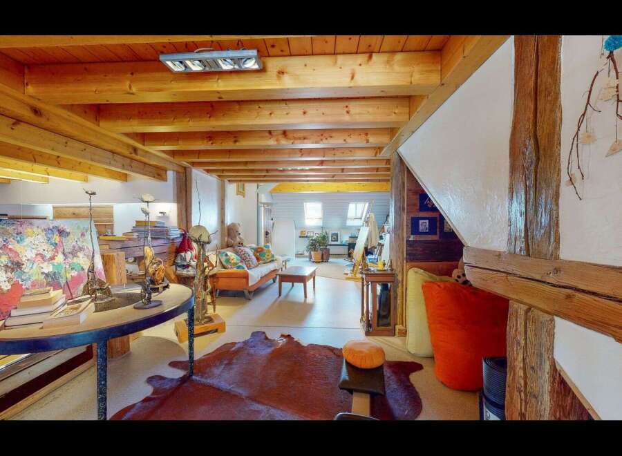 Step into this unique and inviting living space, showcasing exposed wooden beams and a cozy atmosphere.