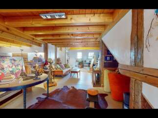 Step into this unique and inviting living space, showcasing exposed wooden beams and a cozy atmosphere.