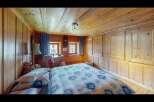 Step into a cozy bedroom retreat, featuring warm wooden paneling that envelops the space.