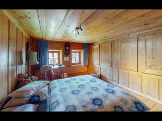Step into a cozy bedroom retreat, featuring warm wooden paneling that envelops the space.