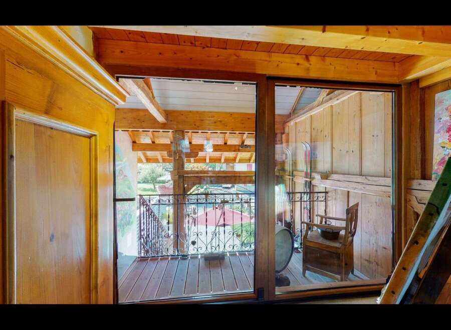 Discover the charm of this unique property featuring a stunning wooden interior and a balcony with a wrought iron railing.
