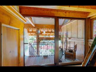 Discover the charm of this unique property featuring a stunning wooden interior and a balcony with a wrought iron railing.