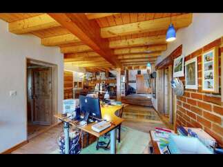 Discover the charm of this unique property featuring exposed wooden beams and a rustic brick wall, creating a warm and inviting atmosphere.
