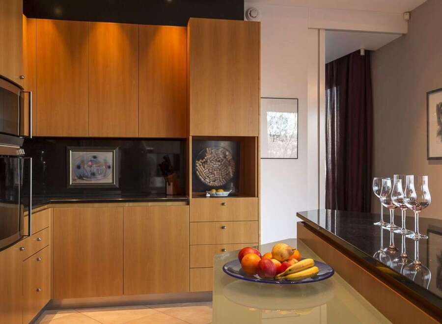 This modern kitchen boasts sleek wooden cabinetry, offering ample storage and a warm aesthetic.