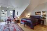 This stunning bedroom boasts a unique design with a sloped ceiling and elegant decor.