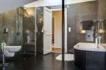 Step into luxury with this stunning bathroom, featuring sleek black tile flooring and a modern glass shower.