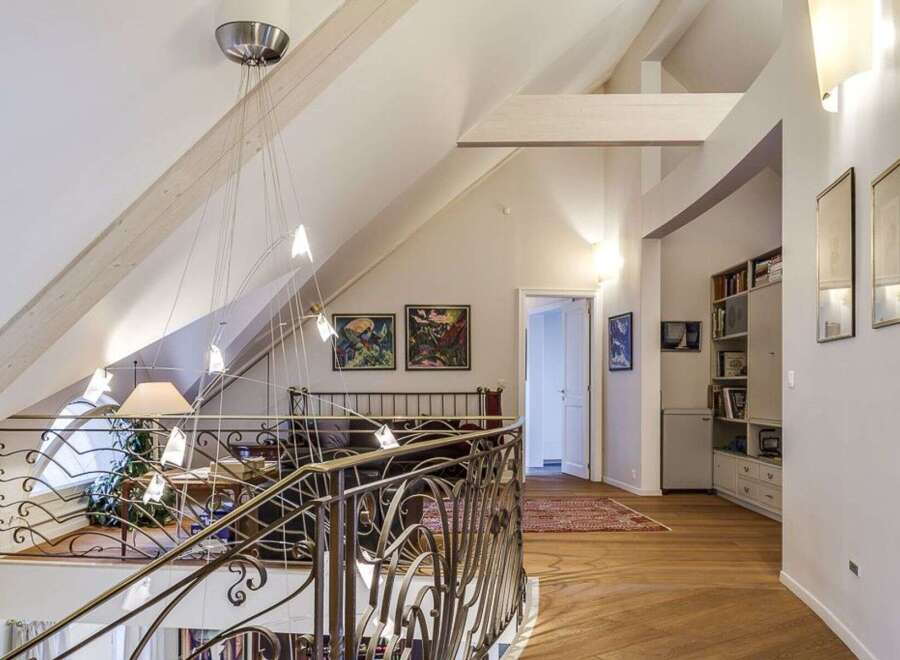 This stunning property boasts a unique architectural design with high ceilings and exposed beams, creating a spacious and airy feel.