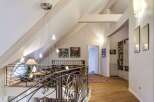 This stunning property boasts a unique architectural design with high ceilings and exposed beams, creating a spacious and airy feel.