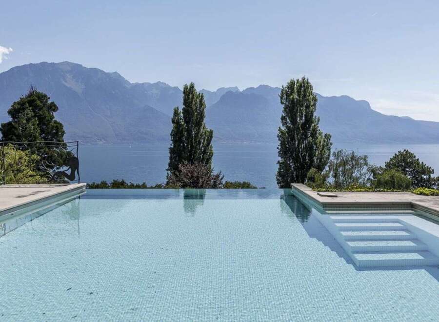 Experience luxury living with this stunning property featuring an infinity pool overlooking breathtaking mountain and lake views.
