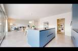 This modern kitchen boasts a sleek blue island, perfect for culinary endeavors and social gatherings.