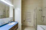 This modern bathroom features a sleek design with a blue countertop and a wooden vanity.