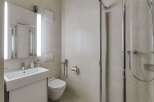 This modern bathroom features a sleek design with a walk-in shower, a stylish sink, and a comfortable toilet.