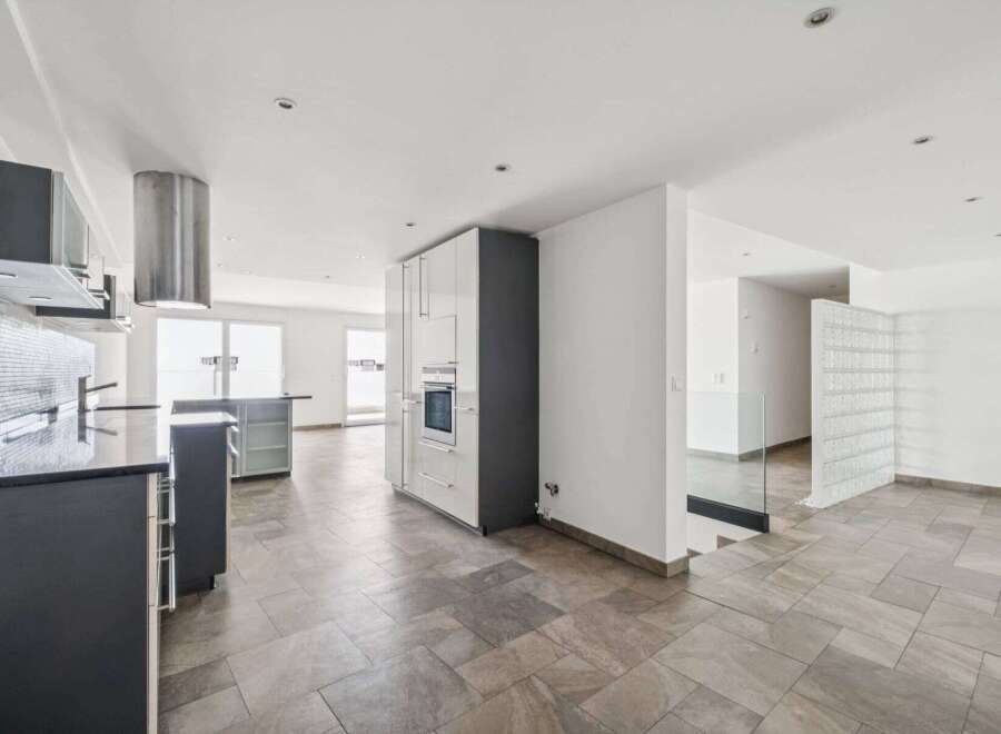 Discover modern living in this stunning property, featuring a sleek kitchen with stainless steel appliances and ample counter space.
