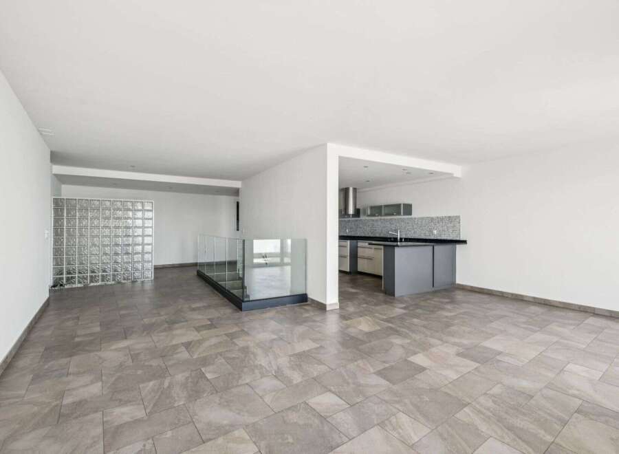 This modern property boasts an open-concept design with a sleek kitchen featuring contemporary cabinetry and countertops.