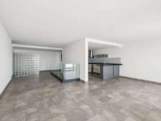 This modern property boasts an open-concept design with a sleek kitchen featuring contemporary cabinetry and countertops.