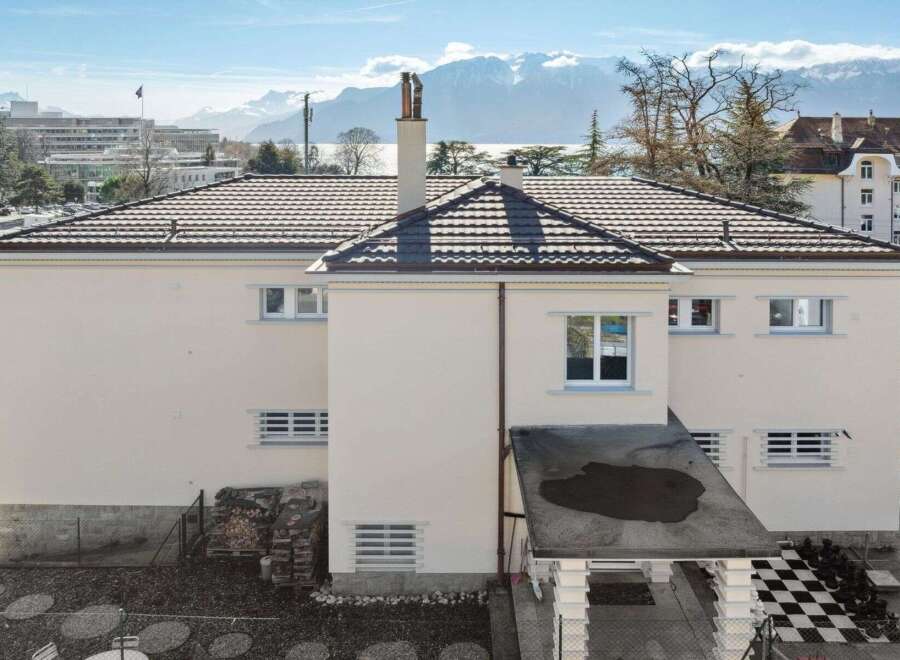 This stunning property boasts a modern design with a beautiful tiled roof and a pristine white exterior.