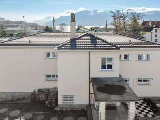 This stunning property boasts a modern design with a beautiful tiled roof and a pristine white exterior.