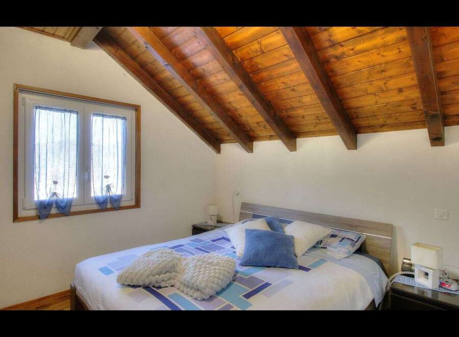 This charming bedroom features a cozy bed with plush pillows and a stylish patterned duvet.
