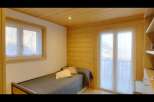 This cozy bedroom features a comfortable single bed with a stylish gray comforter and decorative pillows.