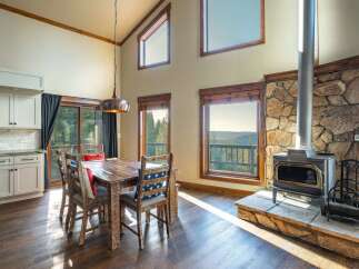 This stunning property boasts a rustic dining area with a beautiful wooden table and chairs, perfect for family gatherings.
